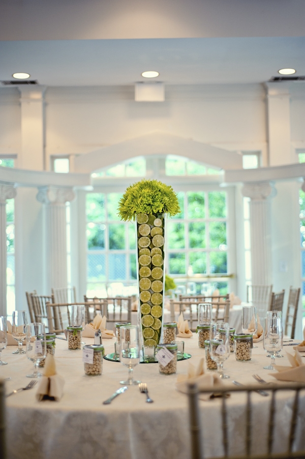 centerpiece filled with limes and topped with green floral detail - green and ivory table setting - wedding photo by top Atlanta based wedding photographers Scobey Photography